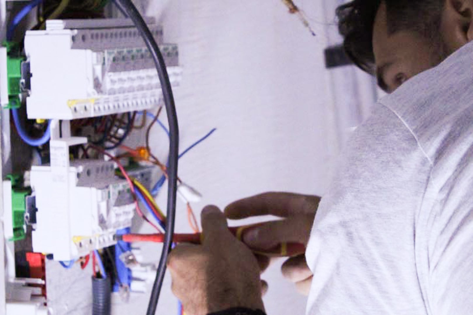 TRAVAUX-ELECTRIQUE3 Électricien câblant un tableau électrique